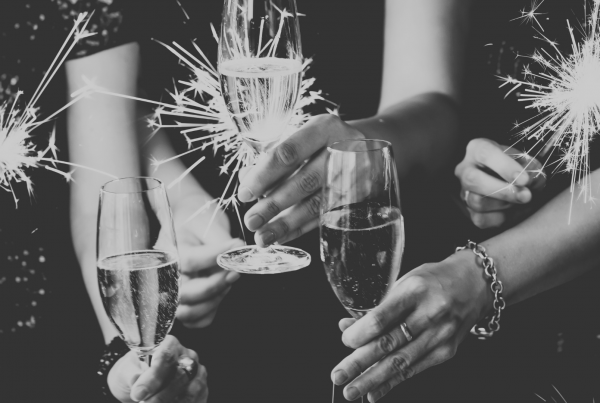Young professionals holding sparklers and wine at a party