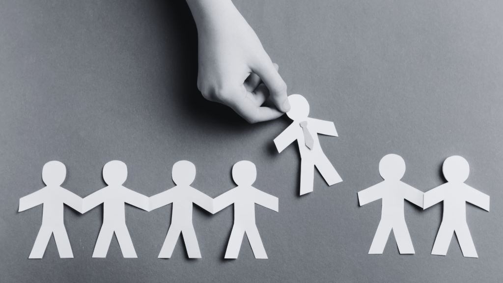 A paper chain of people, with one being pulled out