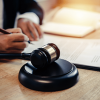 Legal expert writing next to a gavel
