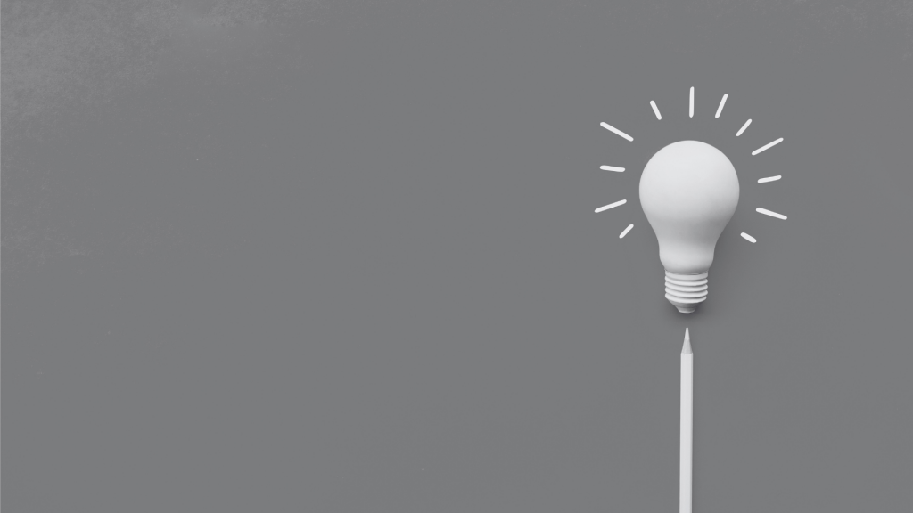 A lightbulb with a pencil beneath it - pencil marks for the bulb being illuminated around it