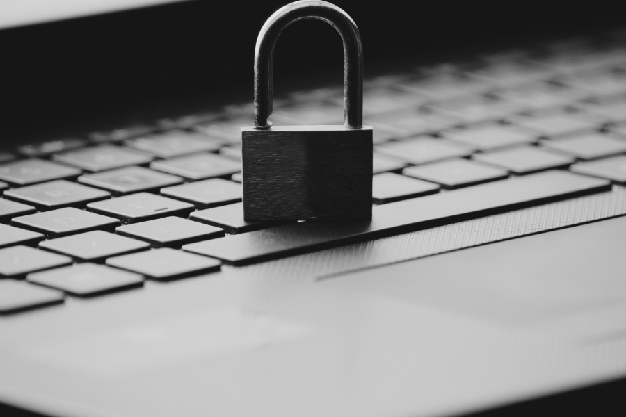 Unlocked padlock sitting on a laptop keyboard