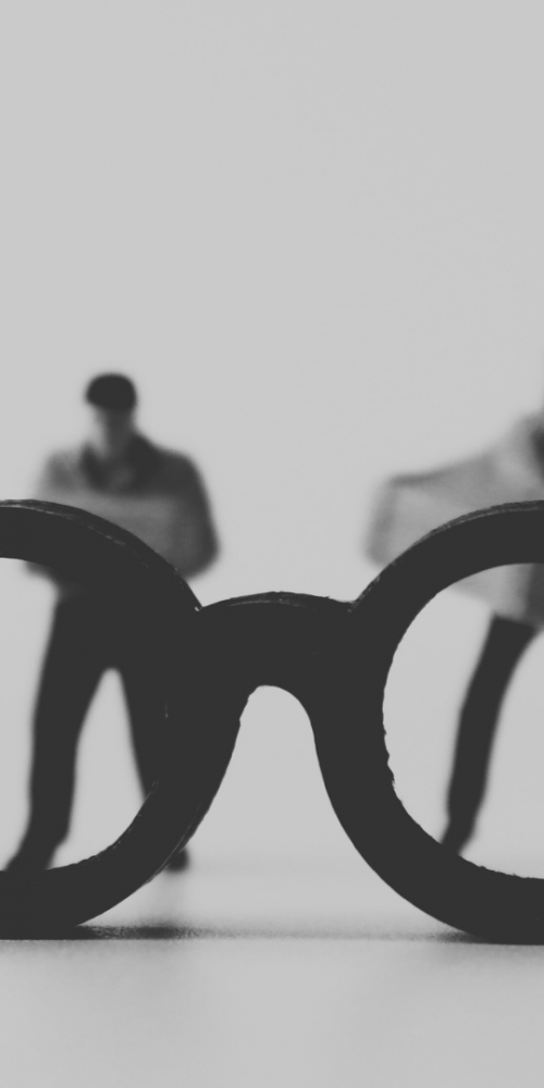 A pair of glasses looking at to different people