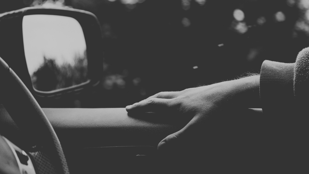 Driving car with arm resting on door