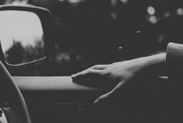 Driving car with arm resting on door