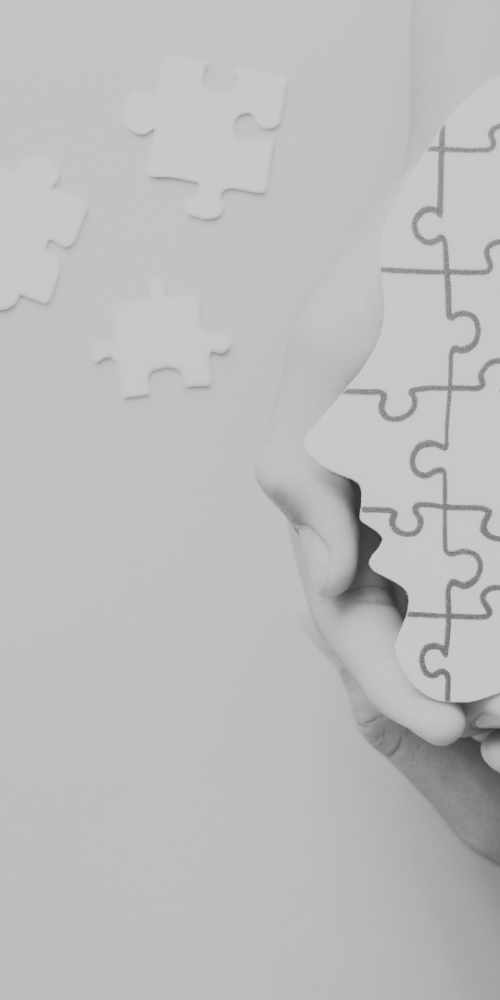 Head jigsaw puzzle being held by multiple hands